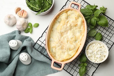 Photo of Tasty vegetarian lasagna and ingredients on white marble table, flat lay
