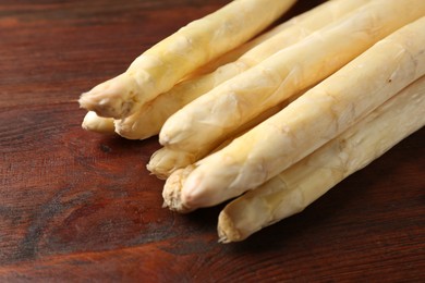 Photo of Many raw asparagus spears on wooden table, closeup. Space for text