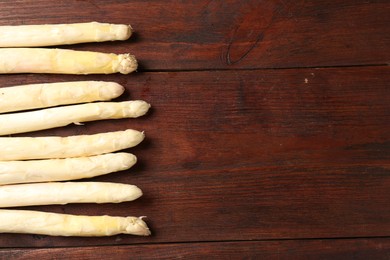 Photo of Many raw asparagus spears on wooden table, flat lay. Space for text