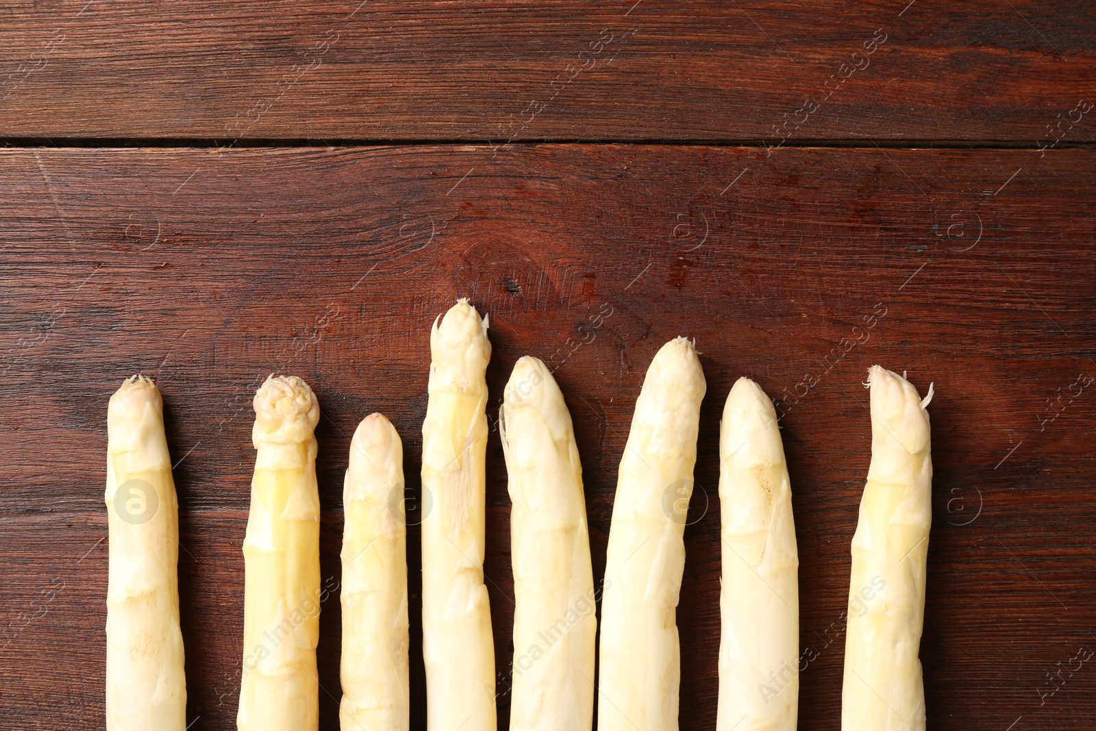 Many raw asparagus spears on wooden table, flat lay. Space for text Photo of Many raw asparagus spears on wooden table, flat lay. Space for text