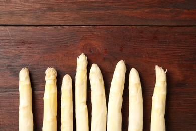 Photo of Many raw asparagus spears on wooden table, flat lay. Space for text