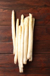 Photo of Many raw asparagus spears on wooden table, top view