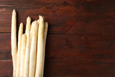 Photo of Many raw asparagus spears on wooden table, top view. Space for text