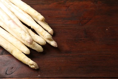 Photo of Many raw asparagus spears on wooden table, above view