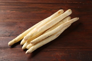 Photo of Many raw asparagus spears on wooden table, above view