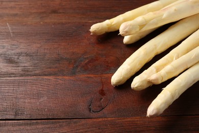 Photo of Many raw asparagus spears on wooden table, closeup, Space for text