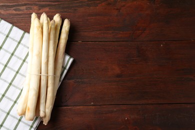 Photo of Raw asparagus spears on wooden table, top view. Space for text