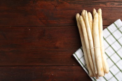 Photo of Raw asparagus spears on wooden table, top view. Space for text