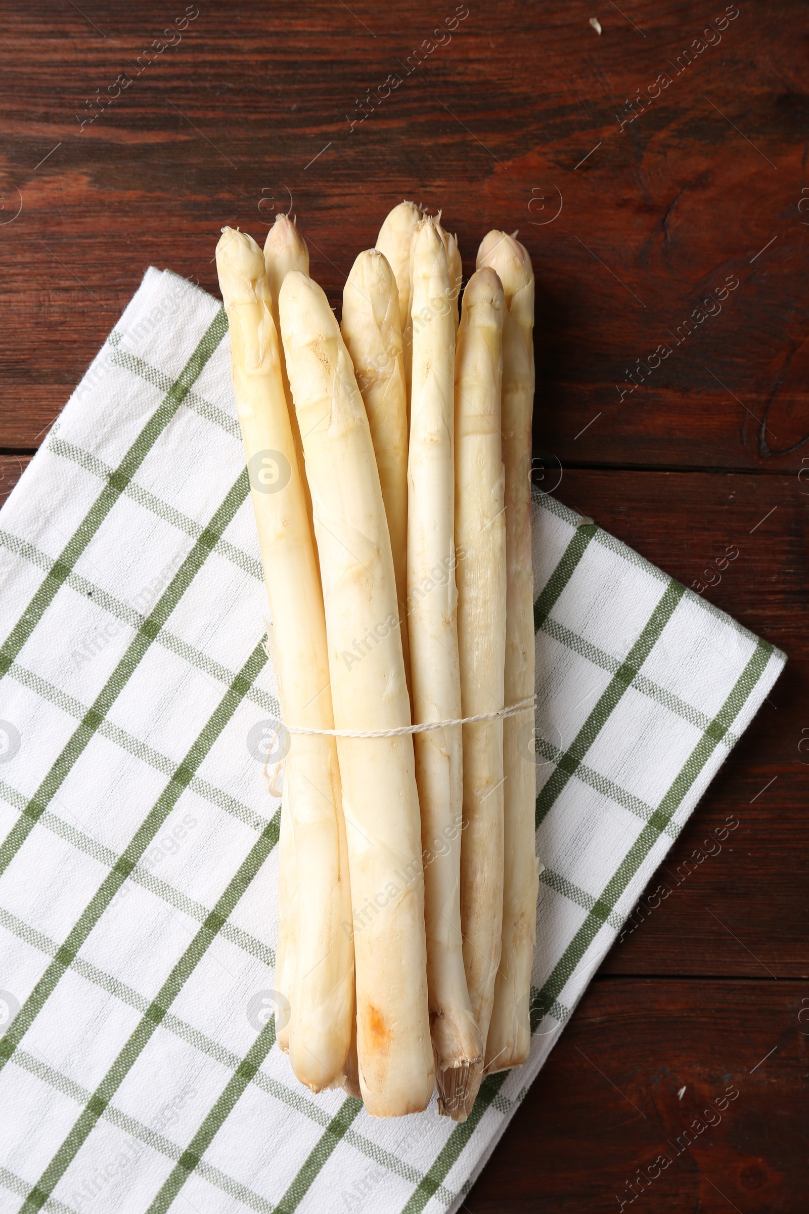 Photo of Raw asparagus spears on wooden table, top view