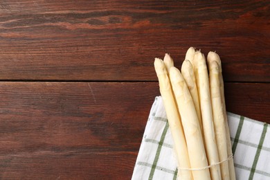 Photo of Raw asparagus spears on wooden table, top view. Space for text