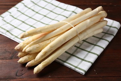 Photo of Raw asparagus spears on wooden table, closeup
