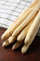 Photo of Raw asparagus spears on wooden table, closeup