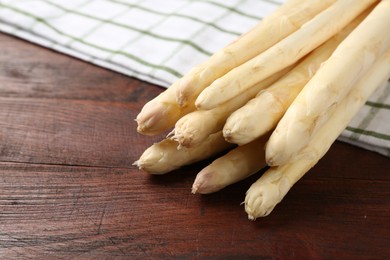Photo of Raw asparagus spears on wooden table, closeup. Space for text