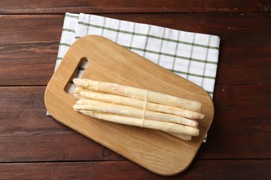 Photo of Raw asparagus spears on wooden table, top view