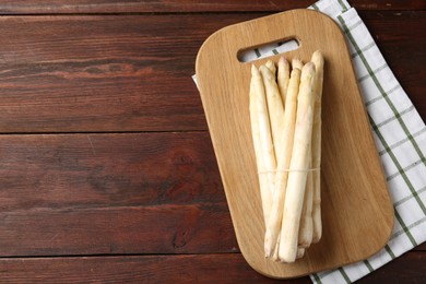 Photo of Raw asparagus spears on wooden table, top view. Space for text