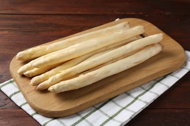 Photo of Raw asparagus spears on wooden table, closeup