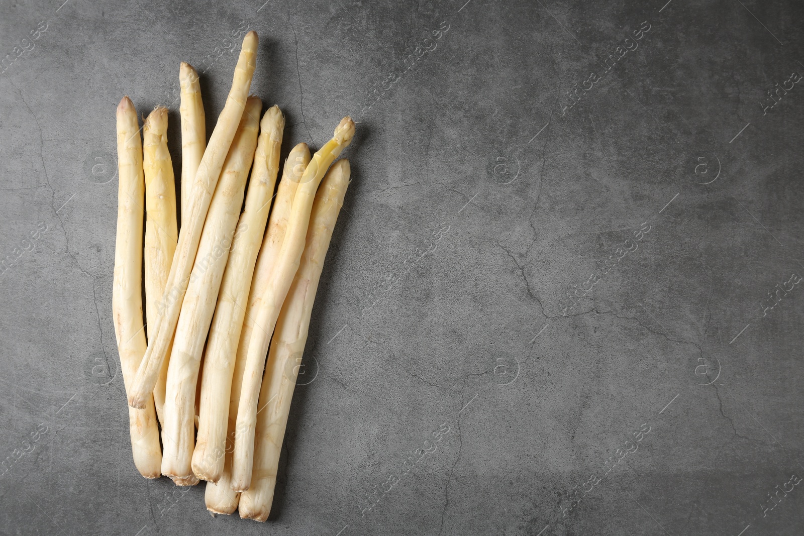 Many raw asparagus spears on grey table, flat lay. Space for text Photo of Many raw asparagus spears on grey table, flat lay. Space for text