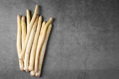 Photo of Many raw asparagus spears on grey table, flat lay. Space for text
