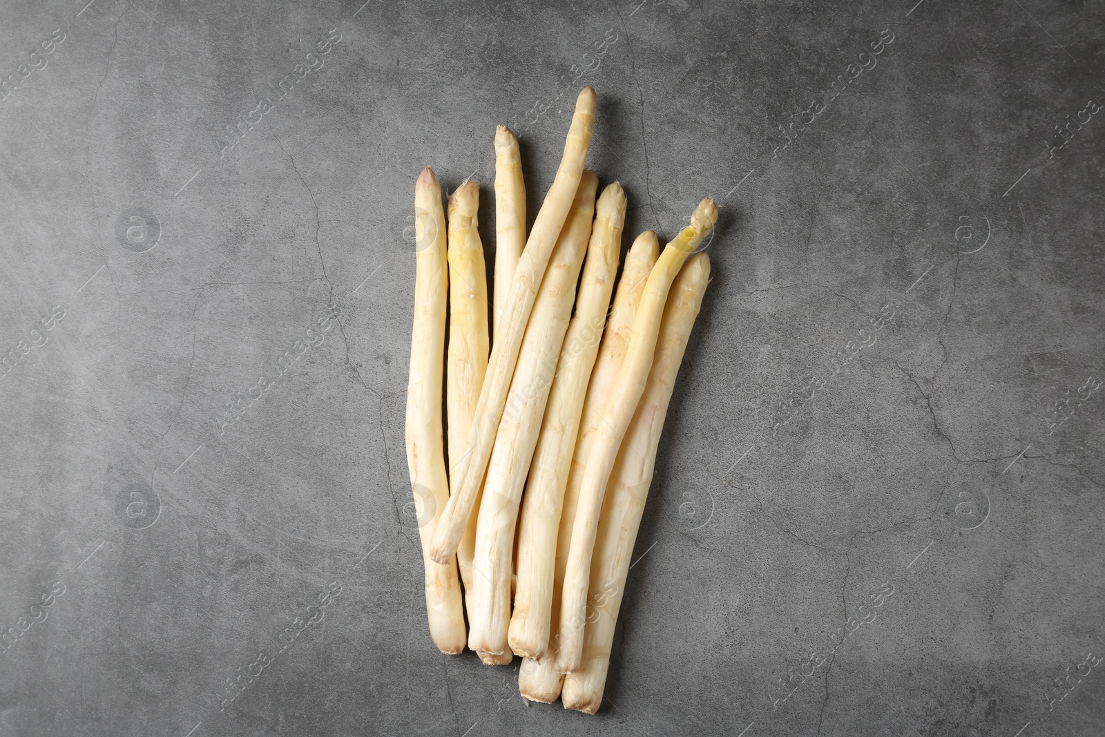 Photo of Many raw asparagus spears on grey table, flat lay