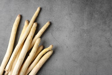 Photo of Many raw asparagus spears on grey table, flat lay. Space for text
