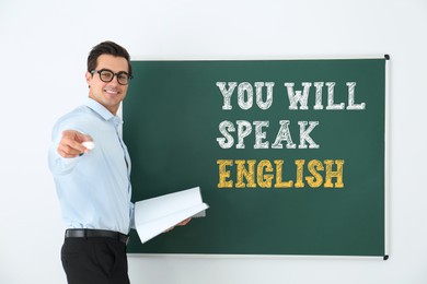 Image of Teacher near green chalkboard with text You Will Speak English. Language course