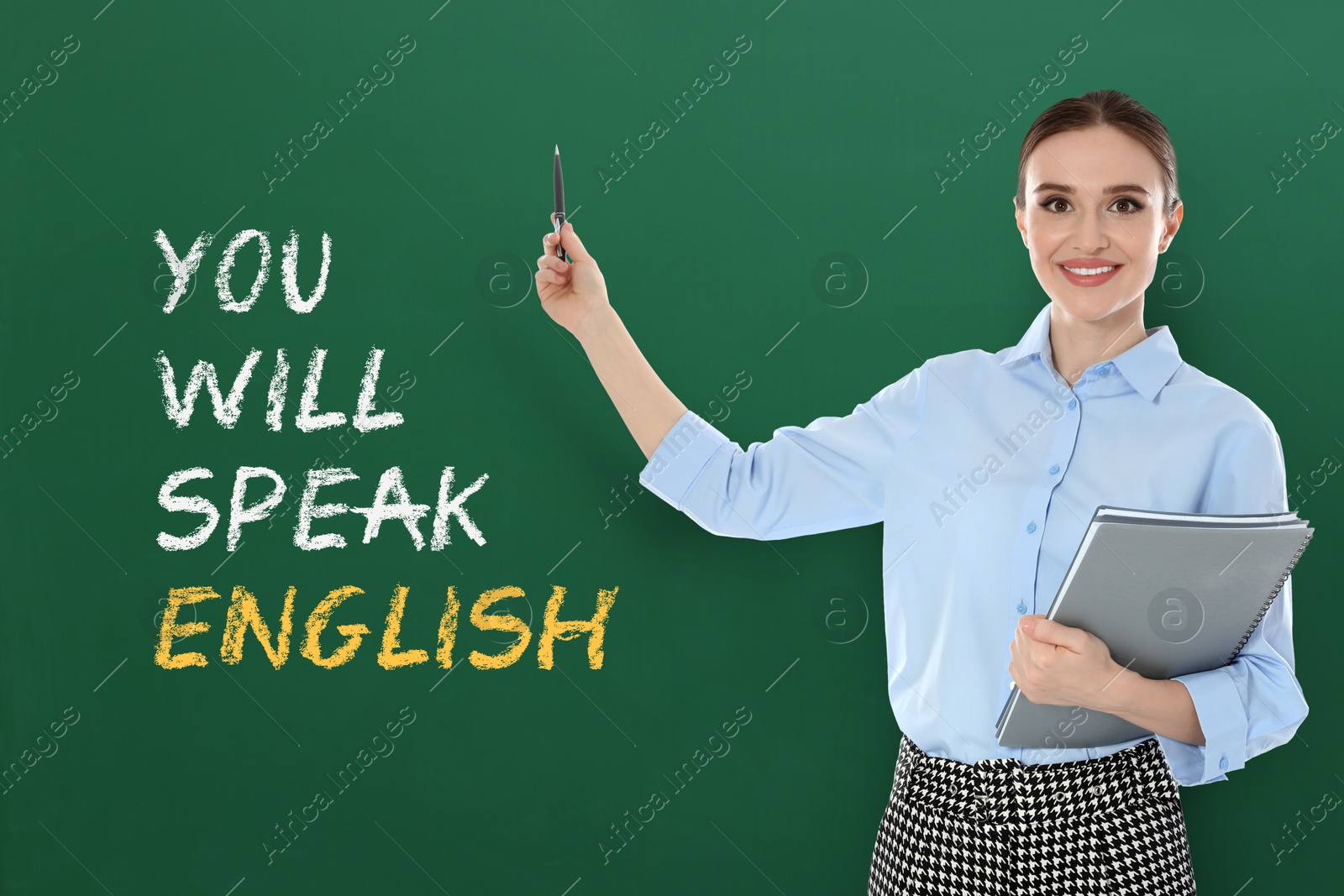 Teacher pointing at green chalkboard with text You Will Speak English. Language course Image of Teacher pointing at green chalkboard with text You Will Speak English. Language course