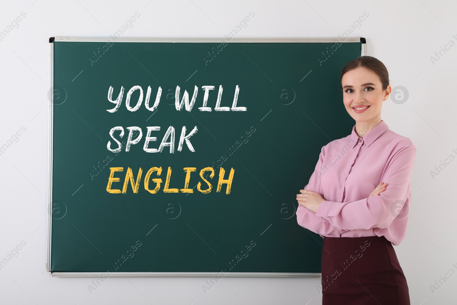 Teacher near green chalkboard with text You Will Speak English. Language course Image of Teacher near green chalkboard with text You Will Speak English. Language course