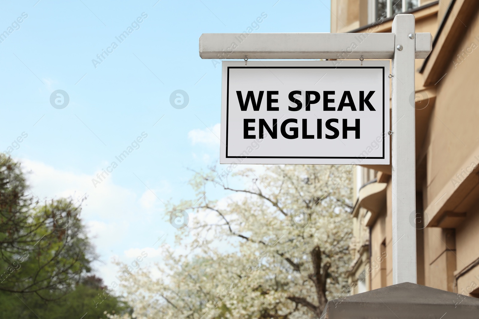 We Speak English text on advertising board in city. Language course Image of We Speak English text on advertising board in city. Language course