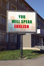 Image of You Will Speak English text on advertising board in city. Language course