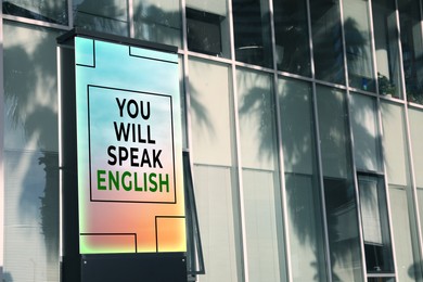 Image of You Will Speak English text on advertising board in city. Language course