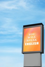 Image of You Will Speak English text on advertising board against blue sky. Language course