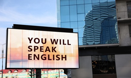 Image of You Will Speak English text on digital billboard in city. Language course