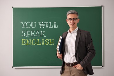 Image of Teacher near green chalkboard with text You Will Speak English. Language course