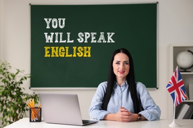 Image of Teacher near green chalkboard with text You Will Speak English in classroom. Language course