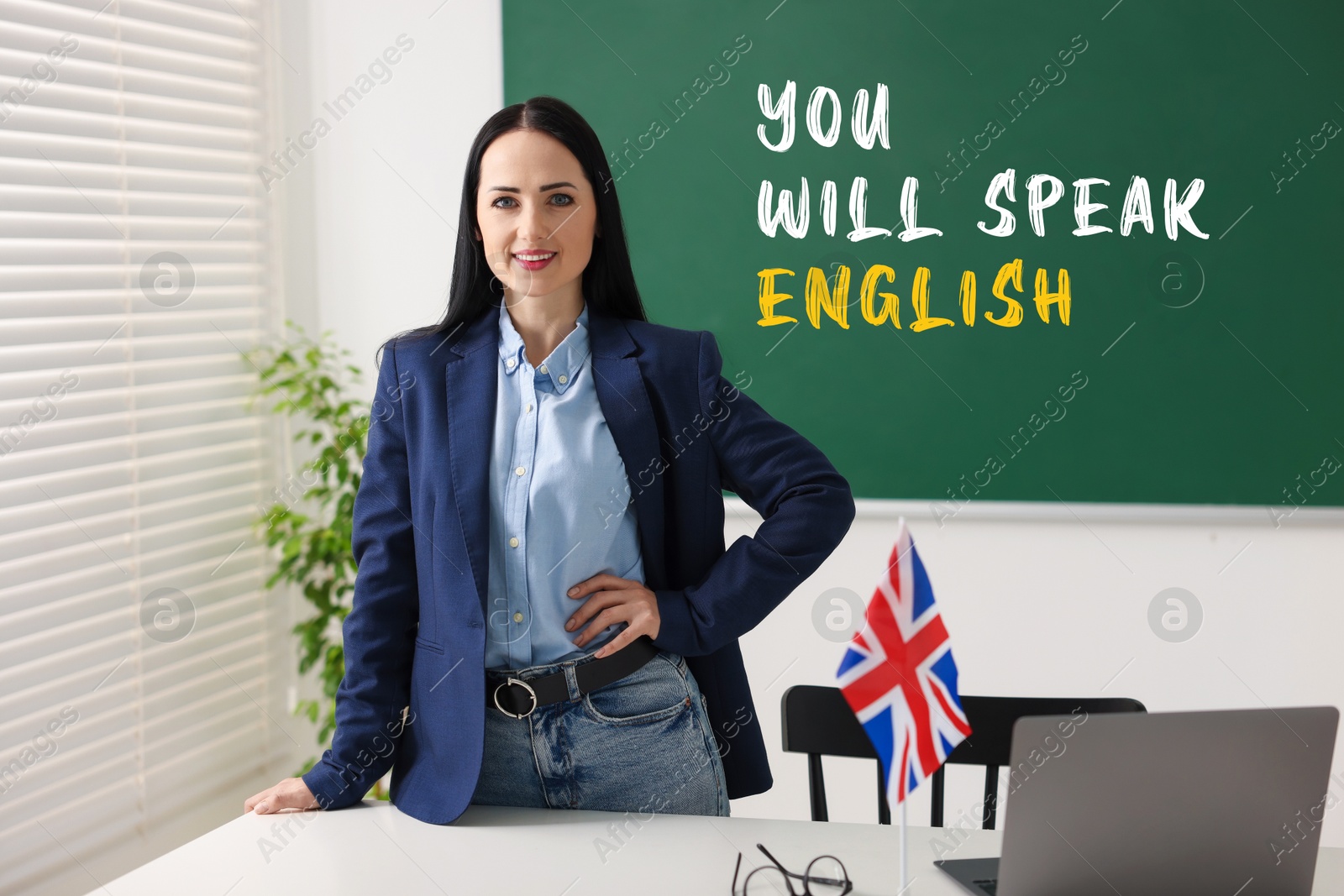 Teacher near green chalkboard with text You Will Speak English in classroom. Language course Image of Teacher near green chalkboard with text You Will Speak English in classroom. Language course