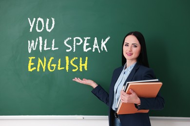Image of Teacher pointing at text You Will Speak English on green chalkboard. Language course