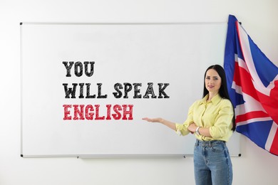 Image of Teacher pointing at text You Will Speak English on whiteboard. Language course