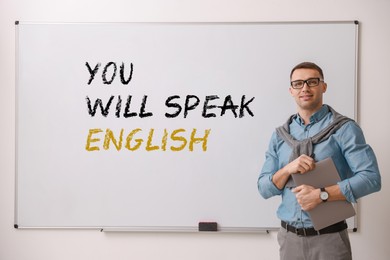 Image of Teacher near whiteboard with text You Will Speak English in classroom. Language course