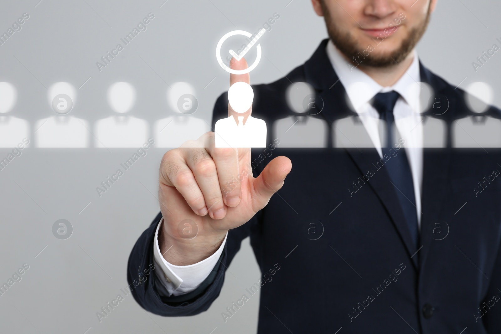 Human resources manager putting check mark over candidate icon on virtual screen against grey background, closeup Image of Human resources manager putting check mark over candidate icon on virtual screen against grey background, closeup