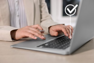 Image of Woman working on laptop at table, closeup. Virtual check mark over computer