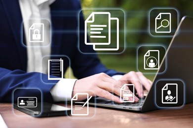Image of Businessman working on laptop at table, closeup, Different document icons on virtual screen