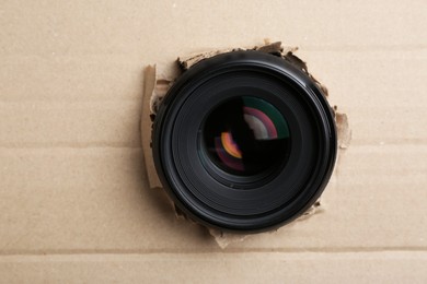 Photo of Hidden camera lens through hole in cardboard, closeup