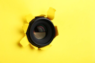 Photo of Hidden camera lens through hole in yellow paper