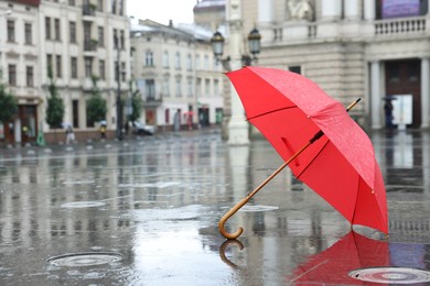 Photo of Red umbrella under heavy rain outdoors, space for text