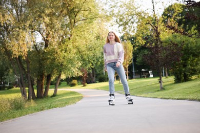 Photo of Beautiful young woman roller skating in park