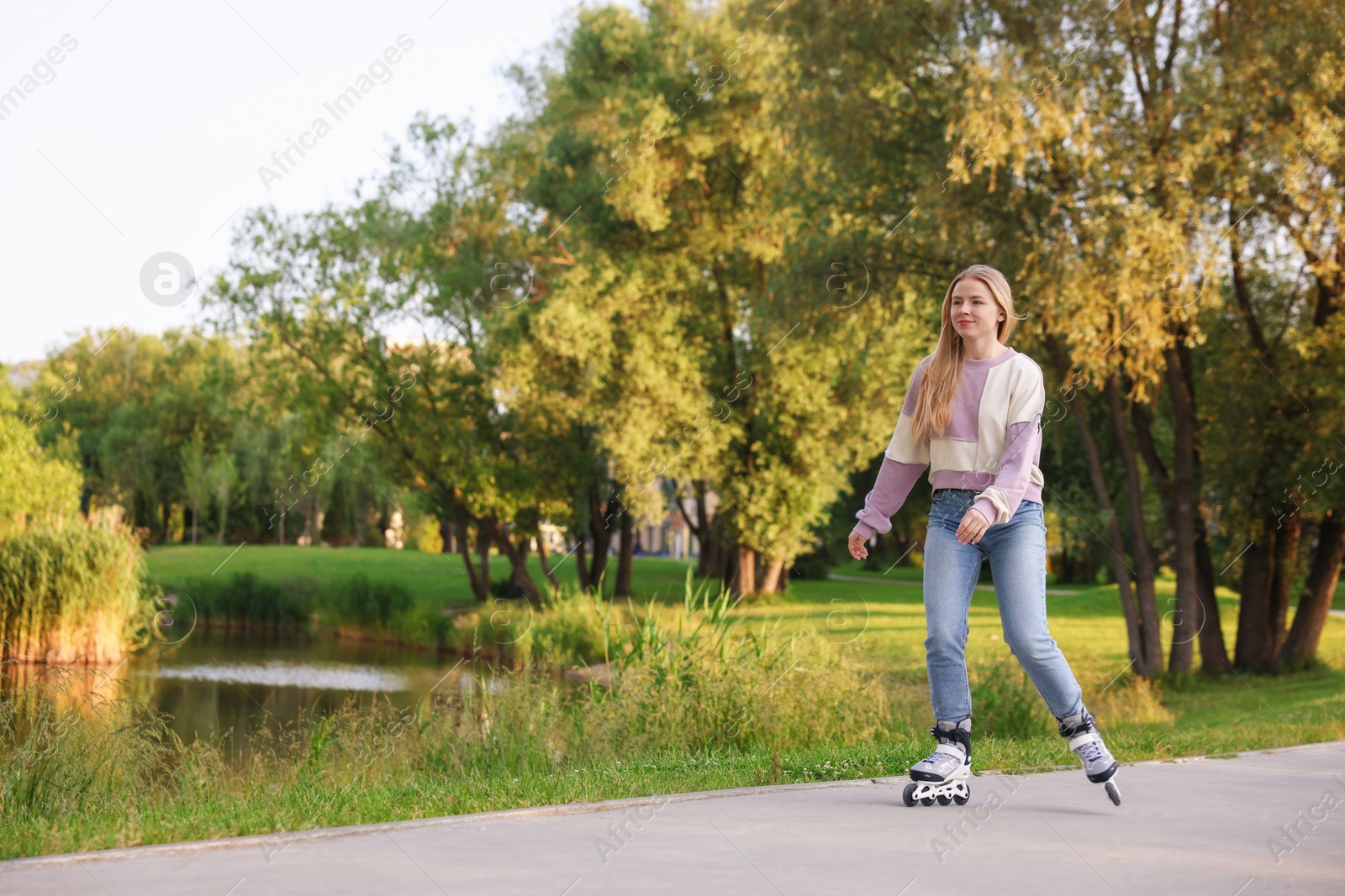 Photo of Beautiful young woman roller skating in park