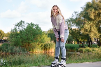 Photo of Happy young woman roller skating in park