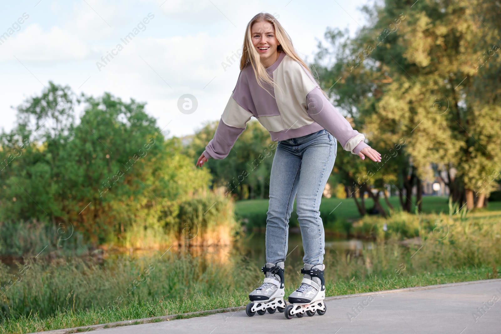 Photo of Happy young woman roller skating in park