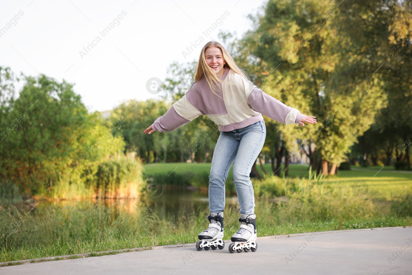 Photo of Happy young woman roller skating in park