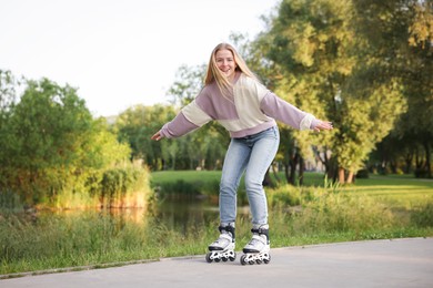 Photo of Happy young woman roller skating in park